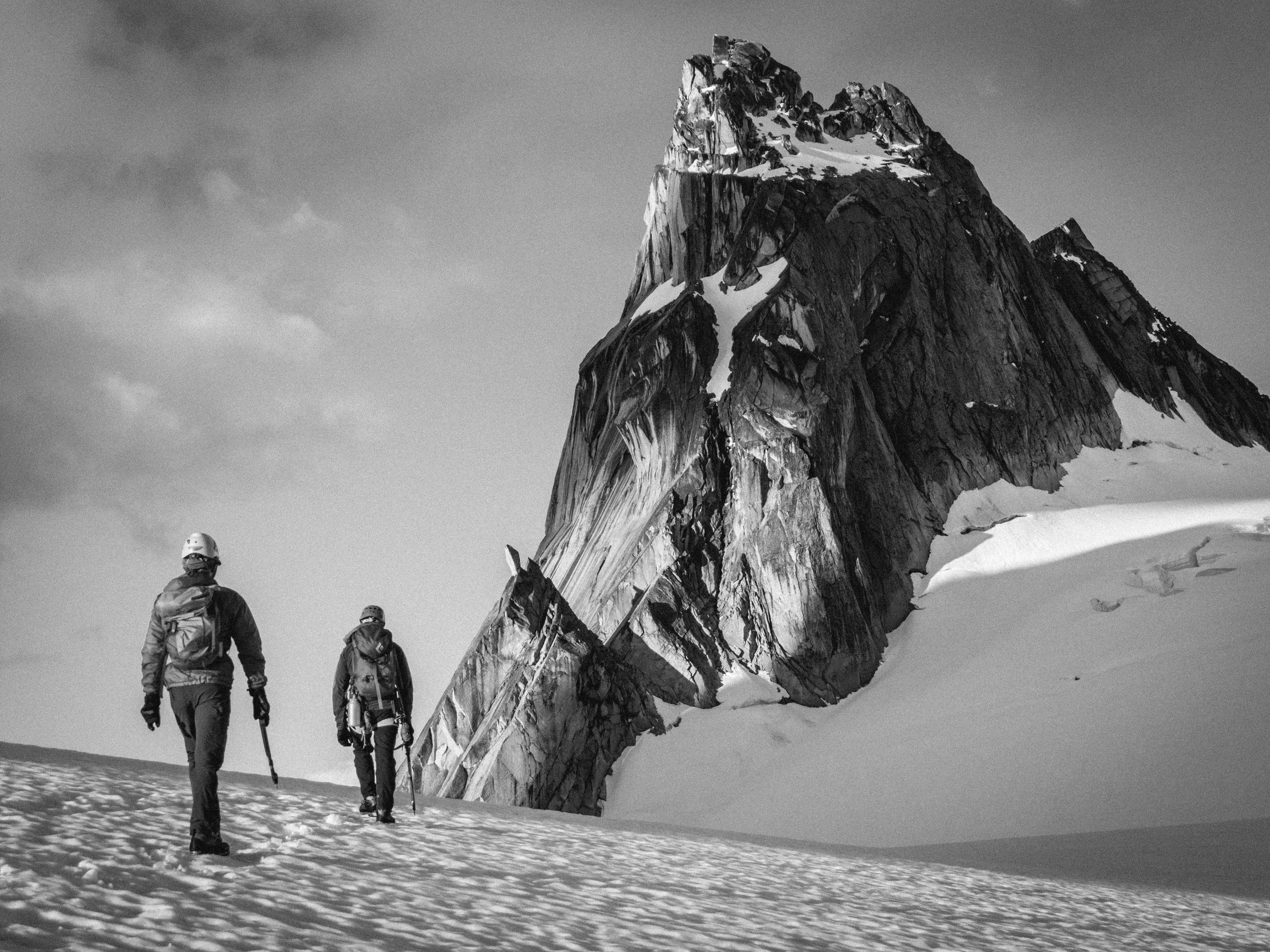 Two people walking on mountain valley